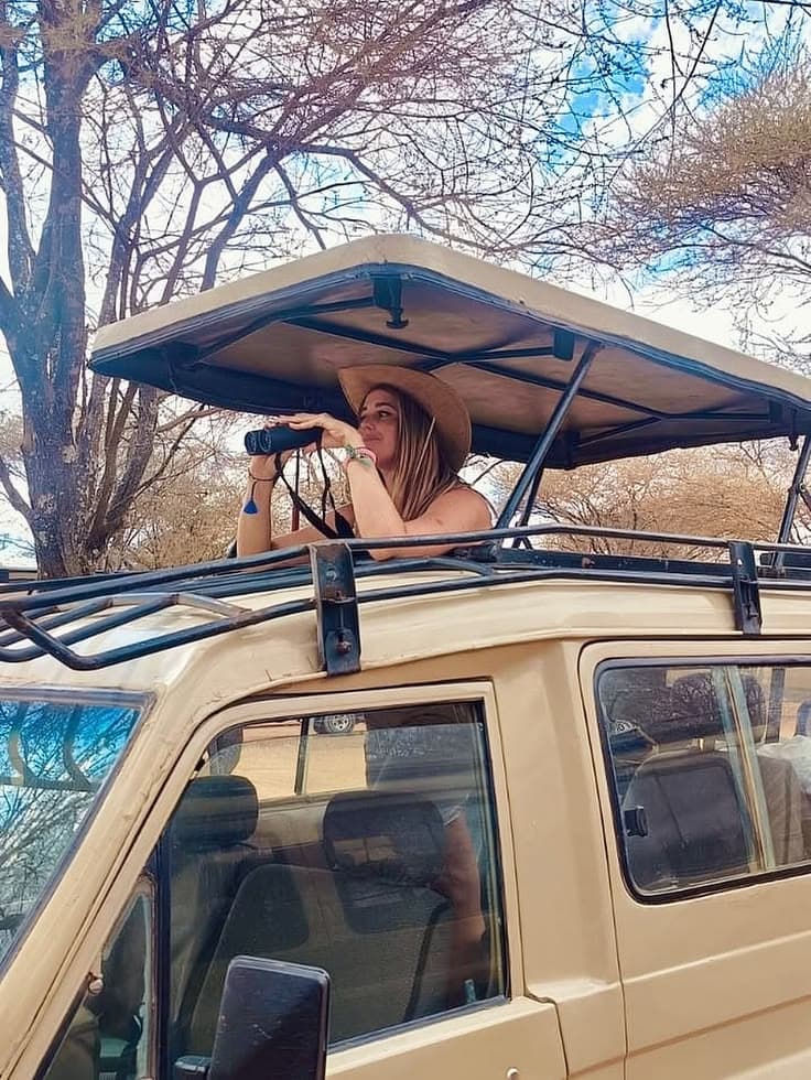 Traveler scanning the horizon from a safari vehicle